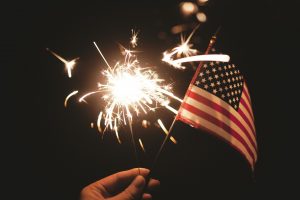 small American flag with sparkler in background
