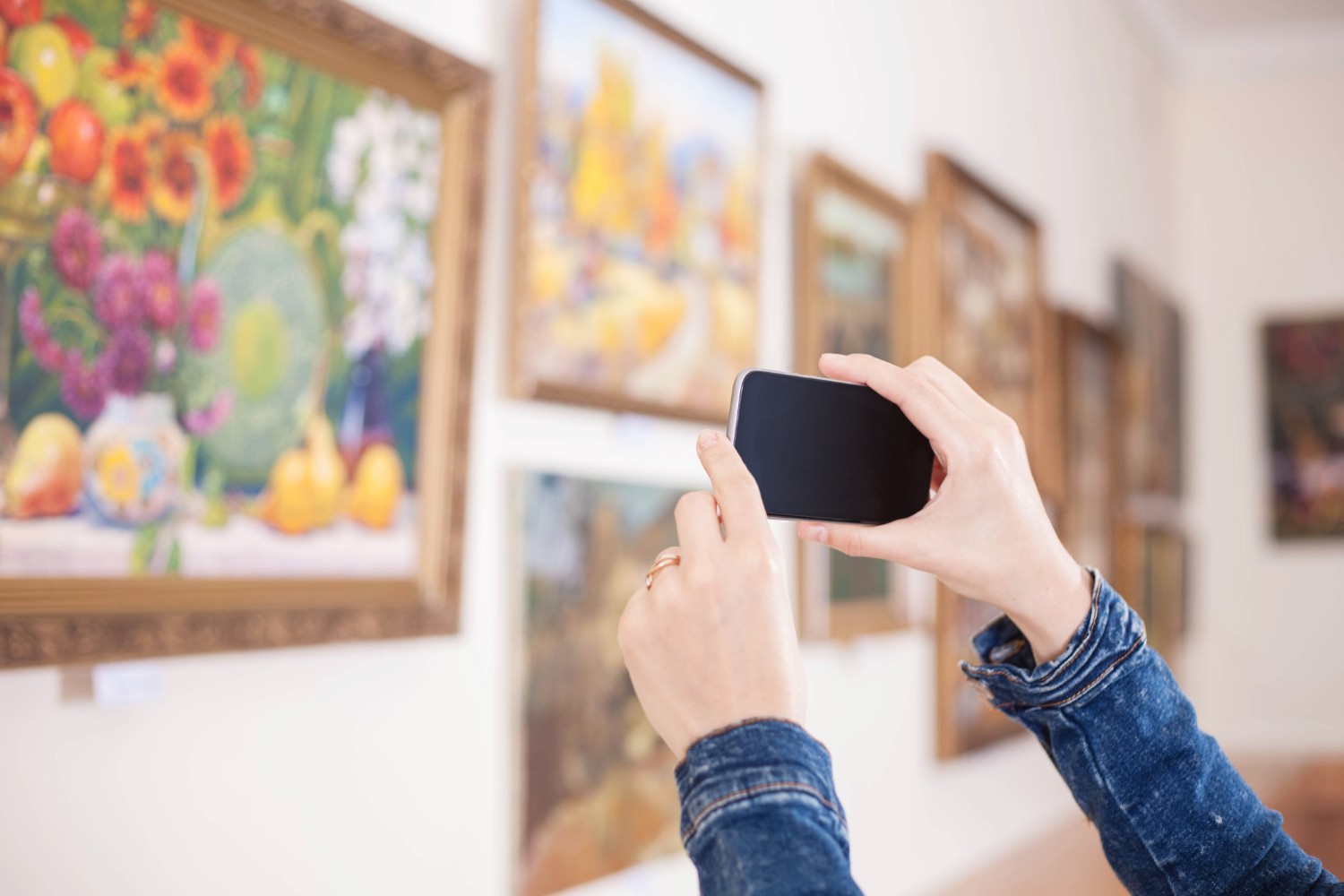 girl taking a picture of a painting at one of the best Aspen museums