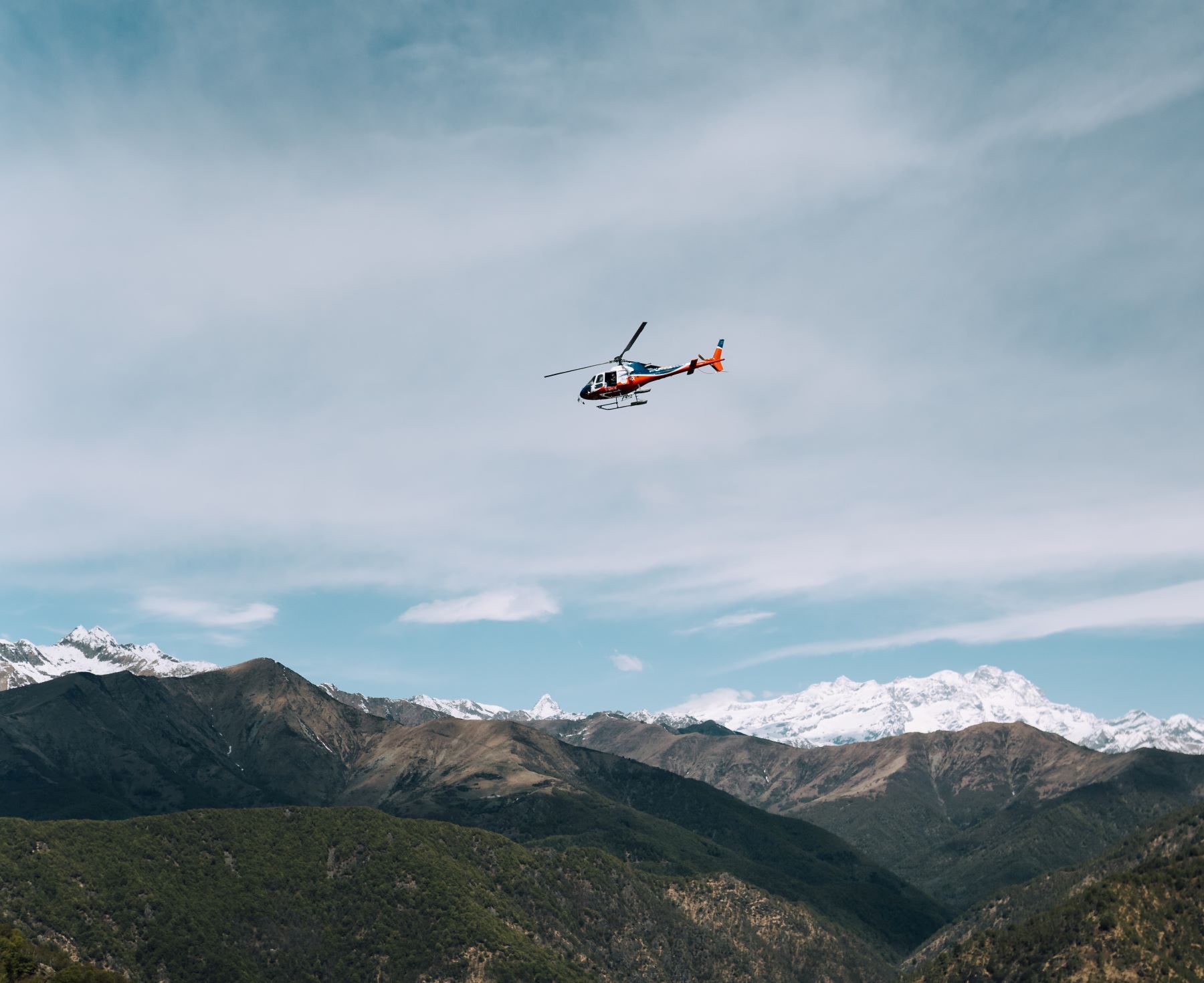 a helicopter flying around a mountain